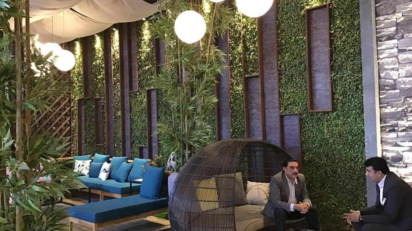 Artificial green wall panels in modern lounge with vertical garden design – join Green Warehouse distributor program for artificial greenery, hedge panels, and vertical gardens