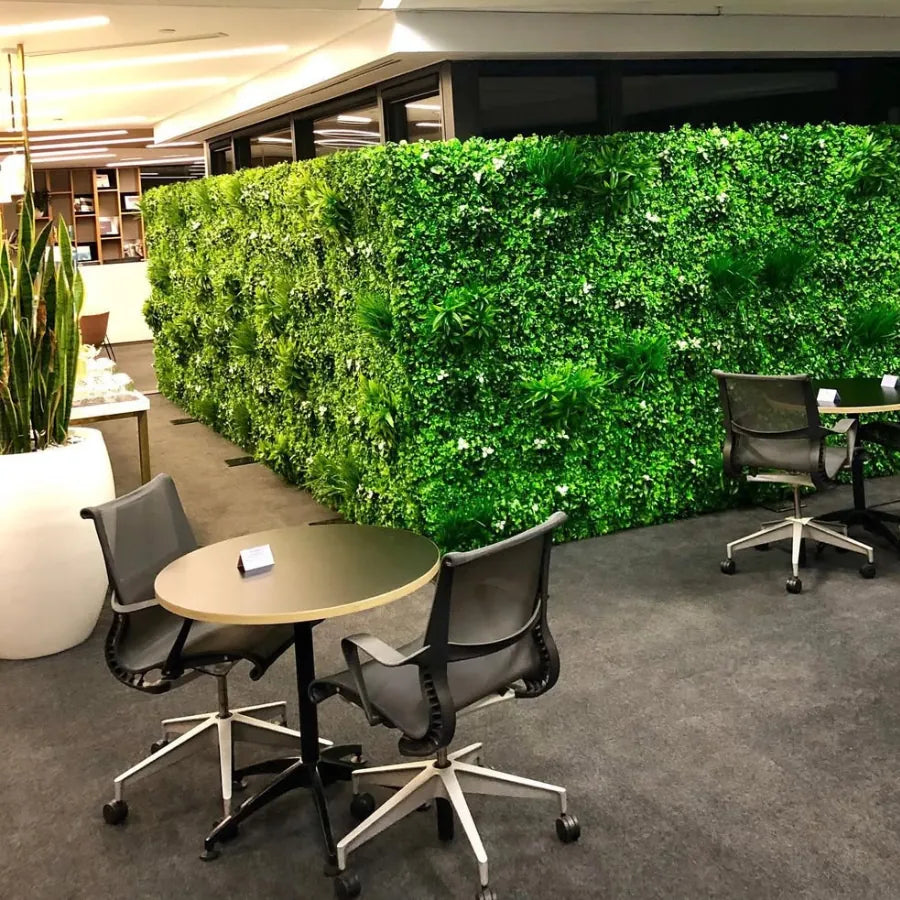 Modern office with artificial green wall panels used as indoor partition to create a vibrant workspace and improve privacy
