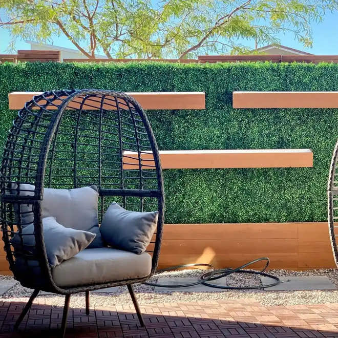 Modern patio with artificial hedge privacy panel and egg chair – UV-protected faux greenery wall for outdoor decor