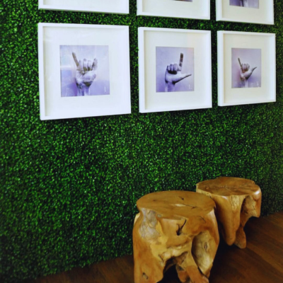 Indoor Artificial Boxwood Wall installed with framed art and natural wooden stools, creating a stylish decorative greenery accent.