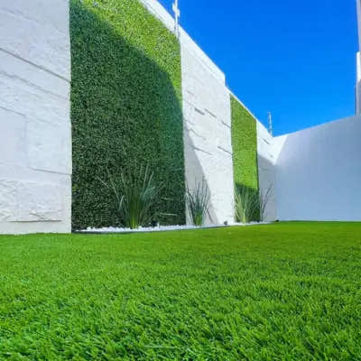 Backyard with artificial boxwood hedge wall panels and synthetic grass installed by Green Warehouse, creating a modern low-maintenance outdoor green space.